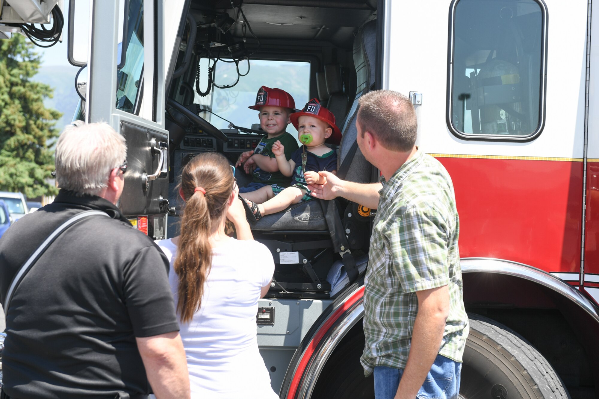 Luke and Wyatt Jeppson, with parents Kyle and Cheryl, admire a fire engine during Wheels of Wonder June 8, 2018, at Hill Air Force Base, Utah. Wheels of Wonder provides base families a fun, hands-on experience exploring various types of vehicles. (U.S. Air Force photo by Cynthia Griggs)