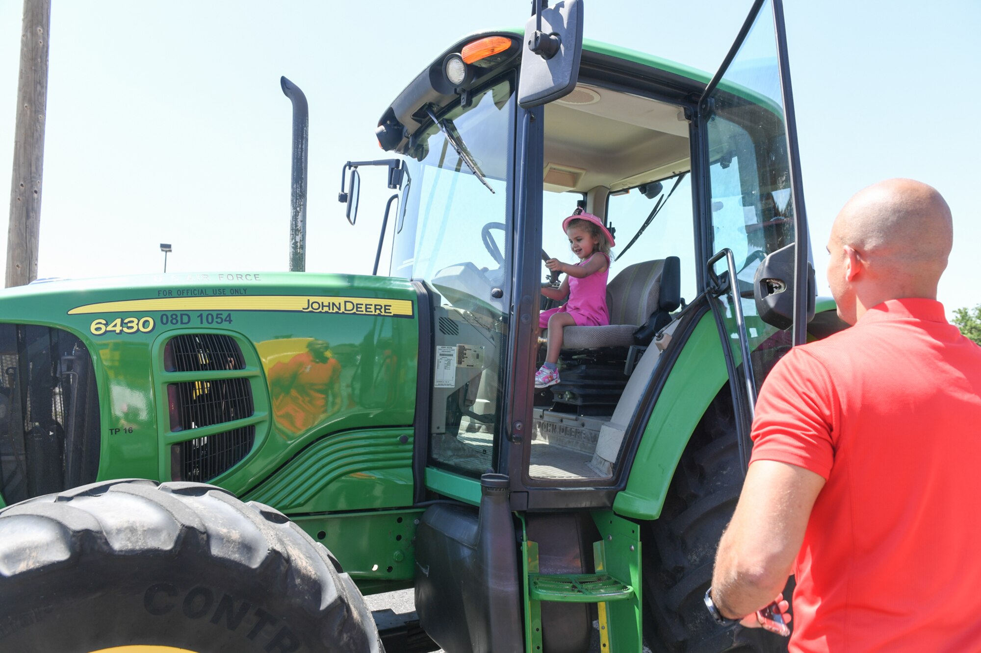 Winnona Walker and her father Matt admire a tractor at Wheels of Wonder June 8, 2018, at Hill Air Force Base, Utah. Wheels of Wonder provides base families a fun, hands-on experience exploring various types of vehicles.