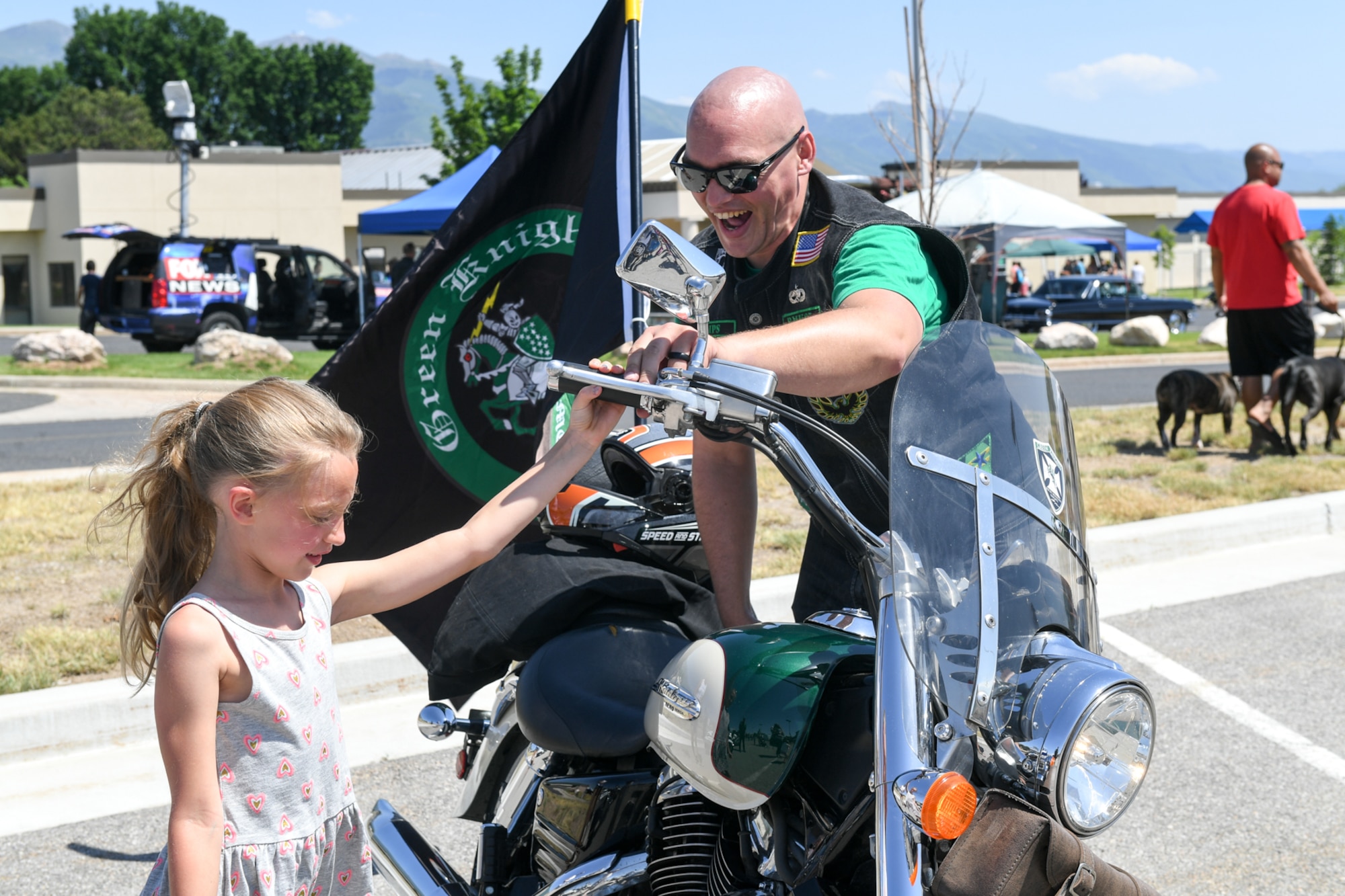 Leila Rose revs the engine of a motorcycle with "Lips," a member of the Green Knights, Chapter 67, during Wheels of Wonder June 8, 2018, at Hill Air Force Base, Utah. Wheels of Wonder provides base families a fun, hands-on experience exploring various types of vehicles. (U.S. Air Force photo by Cynthia Griggs)