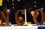 Three NCOs acting on behalf of NCOs of the past, present and future light three candles. The red candle represents valor, the white honor and integrity, and the blue vigilance.