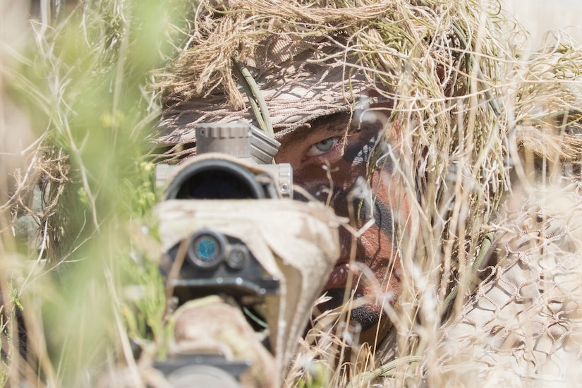 Hidden beneath twigs and weeds, a sniper’s stomach is flat on the ground, dirt and grime on his face. All that can be seen in the bundles of cheatgrass is a pair of steady, intense eyes.