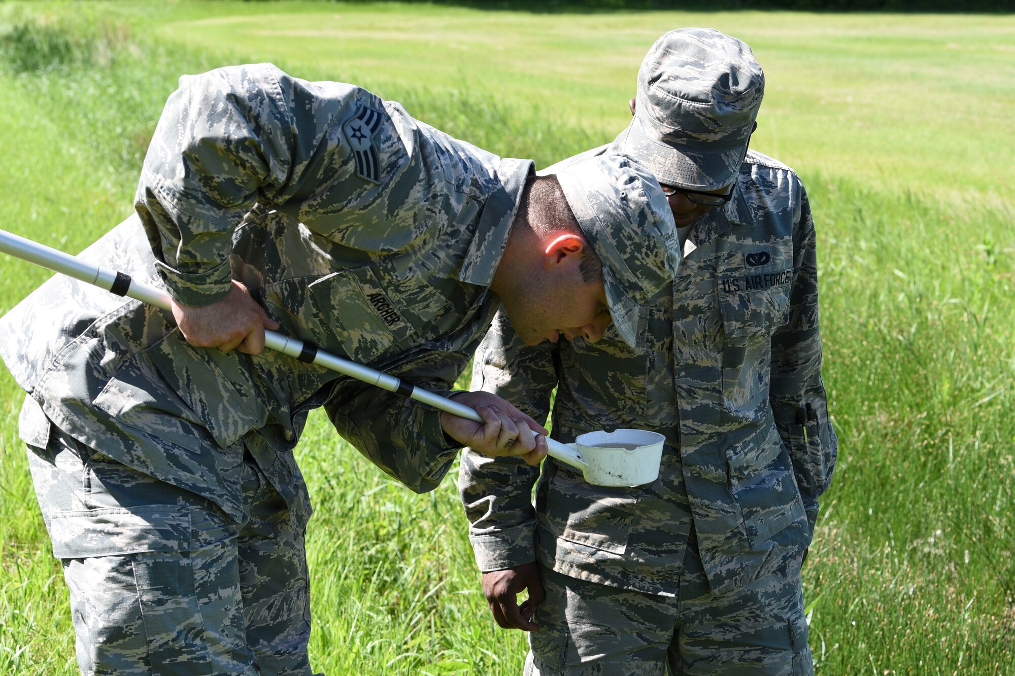 Senior Airman Patrick Archer and Airman 1st Class Jonathon Simmons, both 319th Civil Engineer Squadron pet management journeymen, observe a water sample June 13, 2018, on Grand Forks Air Force Base, North Dakota. The pest management section collects samples of water often to observe and monitor mosquito larvae populations and determine the best course of action. (U.S. Air Force photo by Airman 1st Class Melody Wolff)