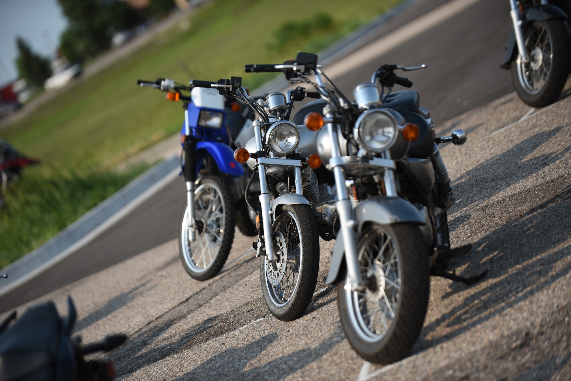 Three motorcycles wait to be ridden during a Wyoming Department of Transportation motorcycle safety course June 10, 2018, at the Department of Motor Vehicles, Cheyenne, Wyo. The course is designed to teach people without any background in motorcycling the basics of riding. (U.S. Air Force Photo by Airman 1st Class Braydon Williams)