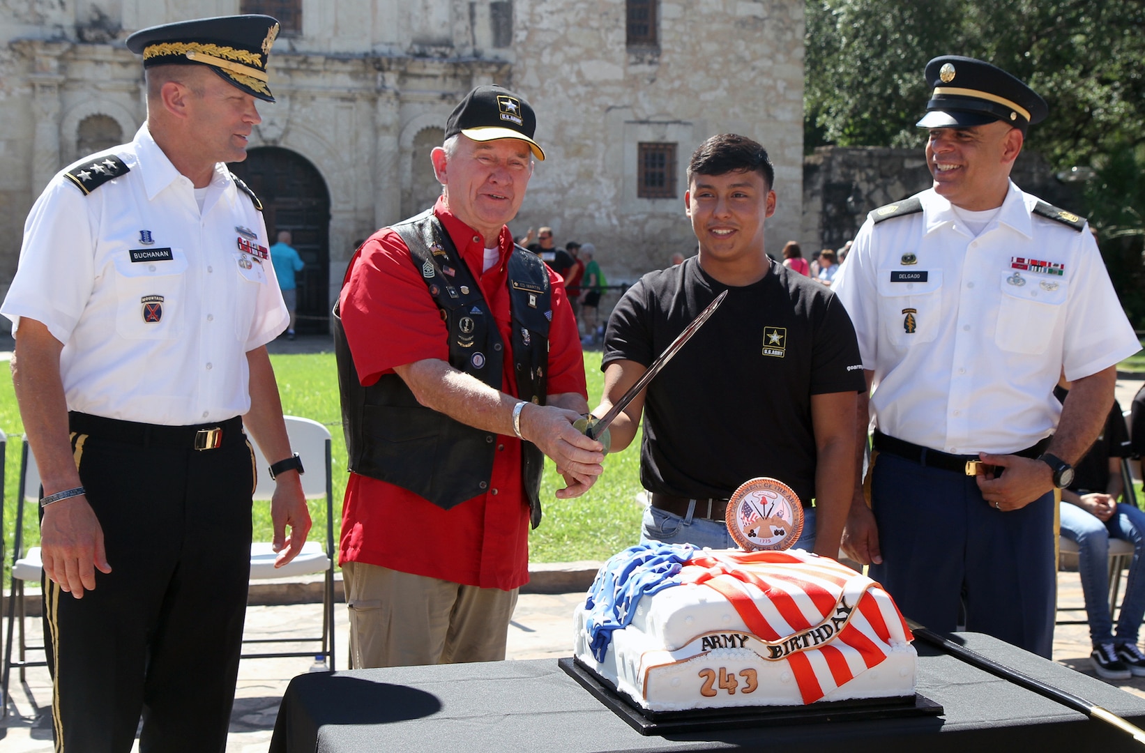 Command Sgt. Maj. (Ret.) Ed Martin, 2nd from left, and Brandon Alvarez, a 2018 graduate of East Central H.S., grasp the saber as they prepare to cut the Army Birthday cake in front of the Alamo on June 14.  The U.S. Army Recruiting Battalion San Antonio marked the Army’s 243rd Birthday with a small ceremony at the historic site.  In keeping with tradition, the oldest Army veteran present, Martin, and the youngest Army Soldier, Ramirez, made the first cut in the cake.  Alvarez took the Oath of Enlistment during the ceremony and is slated to depart for basic training later this year.  The 17-year old enlisted as a Human Resource Specialist.  Also pictured are Army Lt. Gen. Jeffrey S. Buchanan (left) and Command Sgt. Maj. Alberto Delgado (right), the U.S. Army North (Fifth Army) command team.