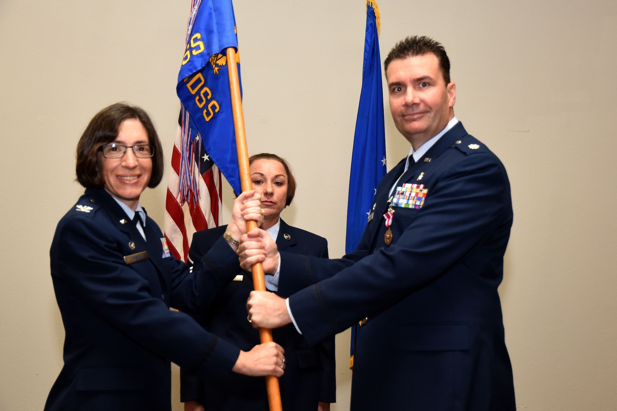 U.S. Air Force Col. Janet Urbanski, 17th Medical Group commander, accepts the guideon from Lt. Col. Achilles Hamilothoris, 17th Medical Support Squadron commander, during the 17th MDSS Change of Command at the Event Center on Goodfellow Air Force Base, Texas, June 15, 2018. The guideon signifies the passing of command from one commander to the next. (U.S. Air Force photo by Airman 1st Class Seraiah Hines/Released)