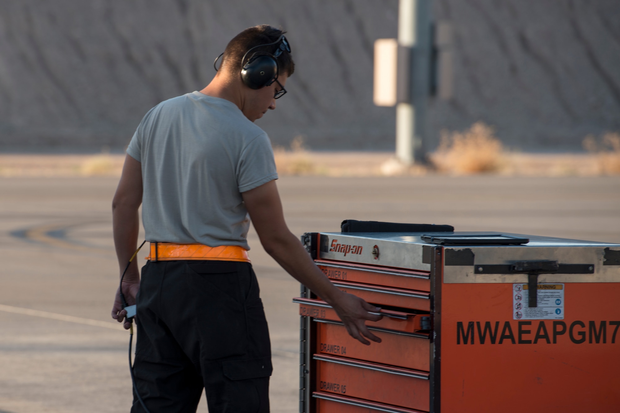 An image of Airman 1st Class Connor Badton, 3911st Fighter Squadron assistant dedicated crew chief, closes a toolbox during Green Flag West, June 13, 2018, at Nellis Air Force Base, Nevada. The 391st FS participated in Green Flag to further enhance readiness by training on Close Air Support over the National Training Center, Fort Irwin, California. (U.S. Air Force Photo by Airman 1st Class JaNae Capuno)