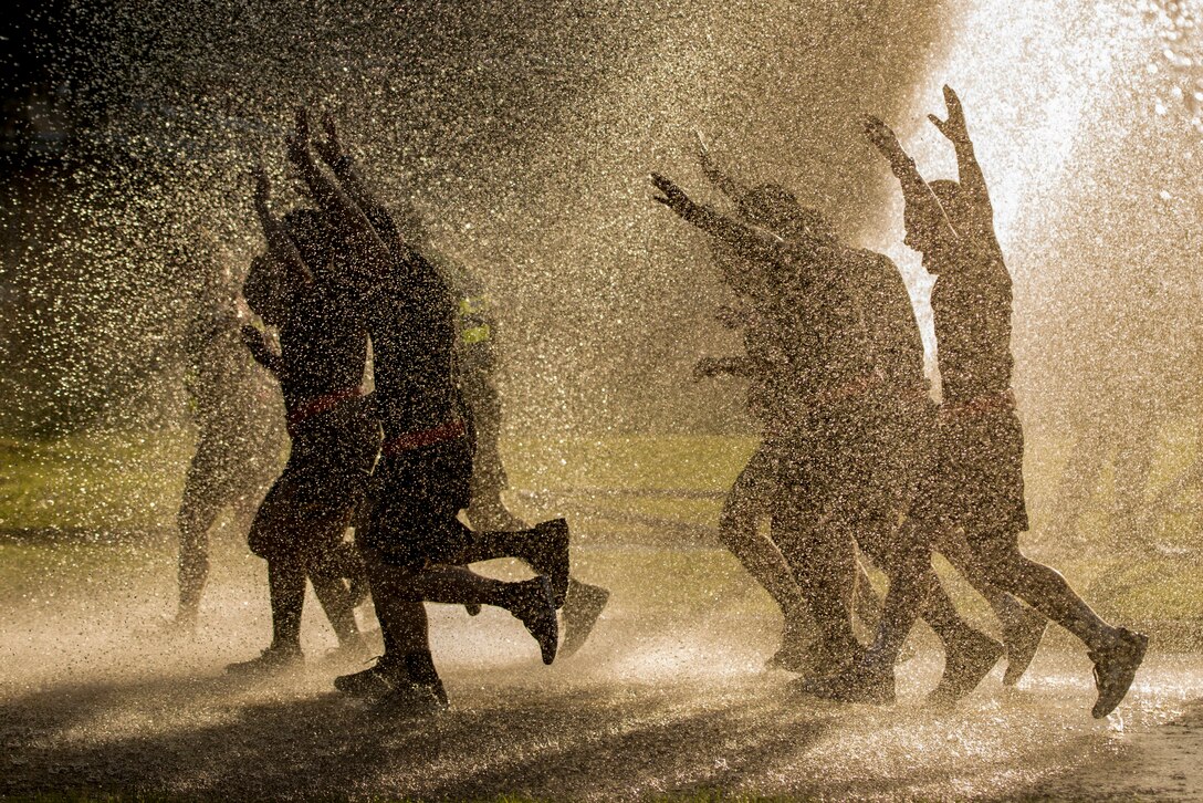 Soldiers run through water.