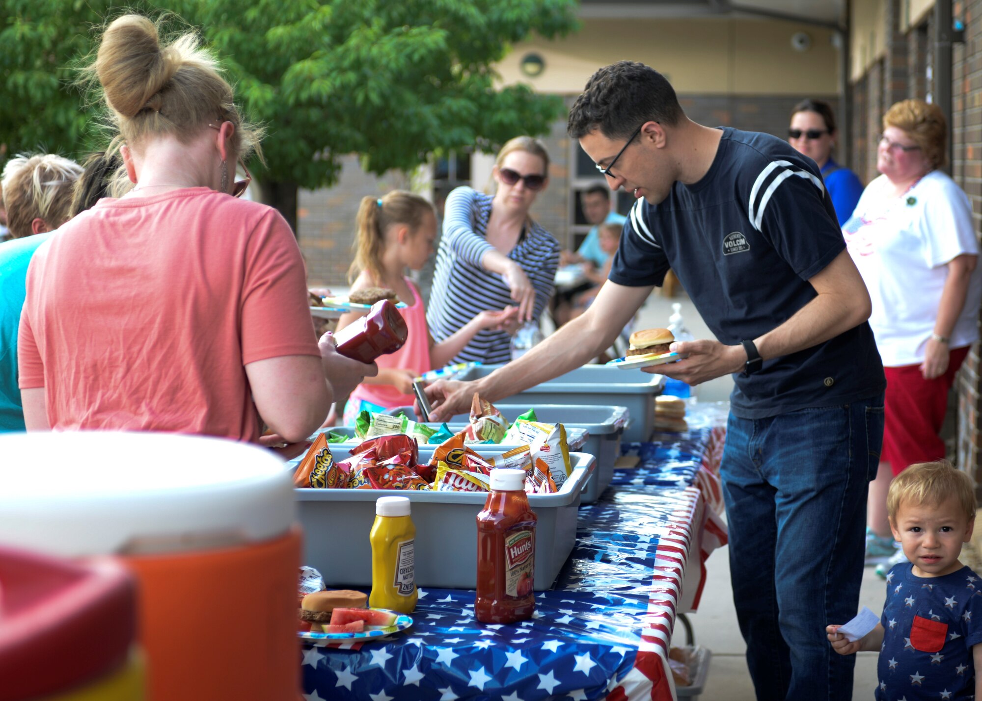 Families line up to get food at the Ellsworth Air Force Base Child Development Center’s Eighth Annual Flag Day Picnic.  Ellsworth Child Development Center celebrated the national observance during their Eighth Annual Flag Day Picnic. (U.S. Air Force photo by Senior Airman Michella Stowers)