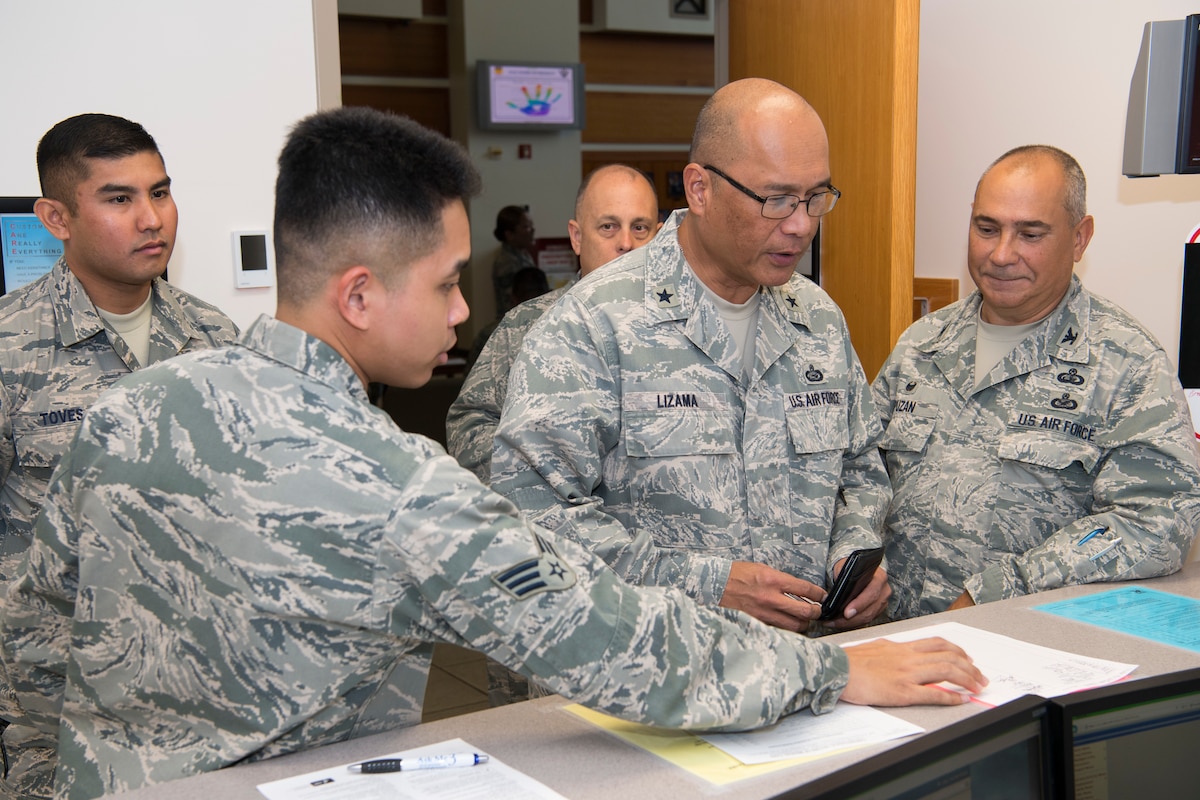 U.S. Air Force Senior Airman John Cortez, Air Force Reserve’s 624th Aerospace Medicine Flight immunizations backup technician, discusses immunization processing with Brig. Gen. Johnny Lizama, Guam National Guard assistant adjutant general – Air, and Col. Timothy Puzan, Air National Guard’s 254th Air Base commander, where Air National Guard Airmen are completing individual medical readiness requirements during a unit training assembly at Andersen Air Force Base, Guam, June 3, 2018.