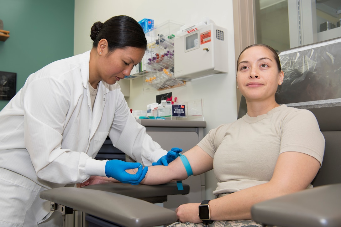 U.S. Air Force Staff Sgt. Audrey Sanchez, Air Force Reserve’s 624th Aerospace Medicine Flight medical laboratory technician, prepares to draw blood from Capt. Jessica Blas, Air National Guard’s 254th Red Horse Squadron personnel officer, as part of individual medical readiness requirements during a unit training assembly at Andersen Air Force Base, Guam, June 3, 2018.