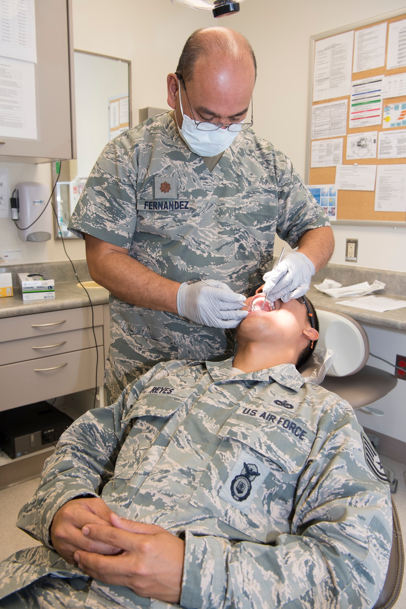 U.S. Air Force Maj. Michael Fernandez, Air Force Reserve’s 624th Aerospace Medicine Flight chief dentist, conducts a dental exam for Tech. Sgt. Joshua Reyes, Air National Guard’s 254th Security Forces Squadron craftsman, as part of individual medical readiness requirements during a unit training assembly at Andersen Air Force Base, Guam, June 3, 2018.
