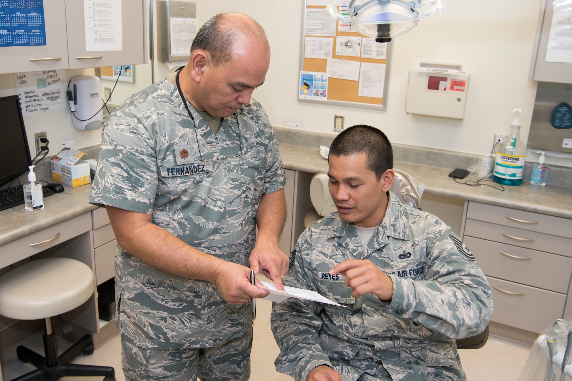 U.S. Air Force Maj. Michael Fernandez, Air Force Reserve’s 624th Aerospace Medicine Flight chief dentist, discusses dental exam results with Tech. Sgt. Joshua Reyes, Air National Guard’s 254th Security Forces Squadron craftsman, as part of individual medical readiness requirements during a unit training assembly at Andersen Air Force Base, Guam, June 3, 2018.