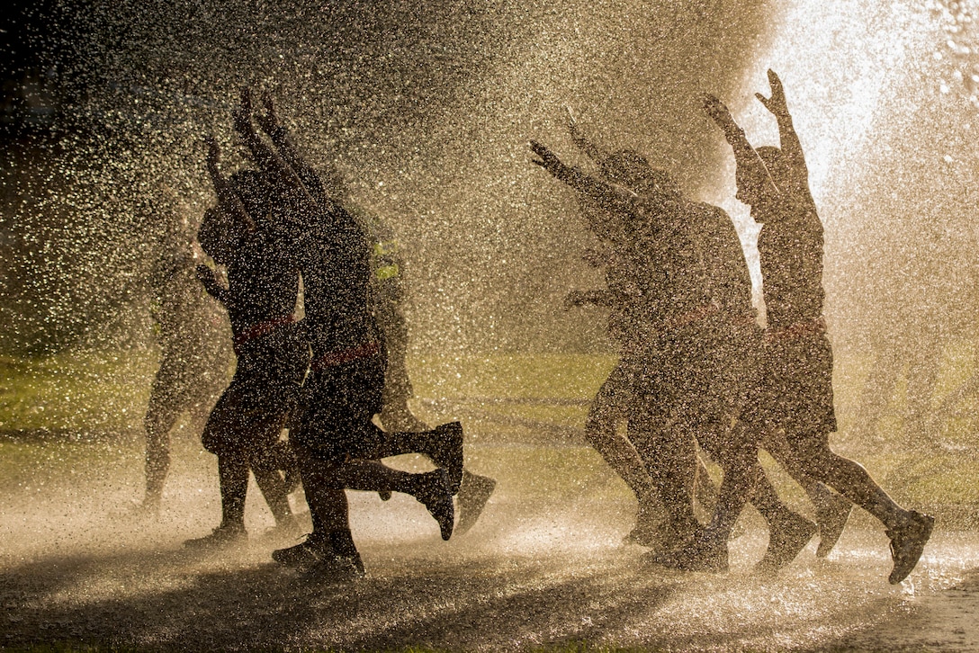 Soldiers run through water.