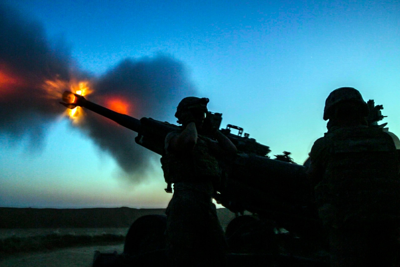 Soldiers fire artillery.