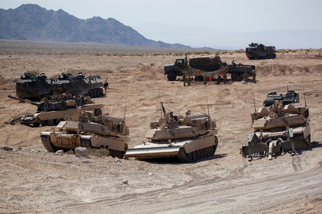 Marines with 4th Combat Engineer Battalion, 4th Marine Division, 4th Tank Battalion, 4th MarDiv, and 4th Assault Amphibious Vehicle Battalion, 4th MarDiv, stage their M1A1 Abrams main battle tanks, Assault Amphibious Vehicles and Assault Breacher Vehicles for a second evolution of an obstacle clearing detachment practical application, during Integrated Training Exercise 4-18, aboard Marine Corps Air Ground Combat Center Twentynine Palms, California, June 12, 2018. The OCD training was conducted to prepare Marines for the execution of a live-fire combined arms breach in which mechanized units will detonate a 1,000 pound mine clearing charge.