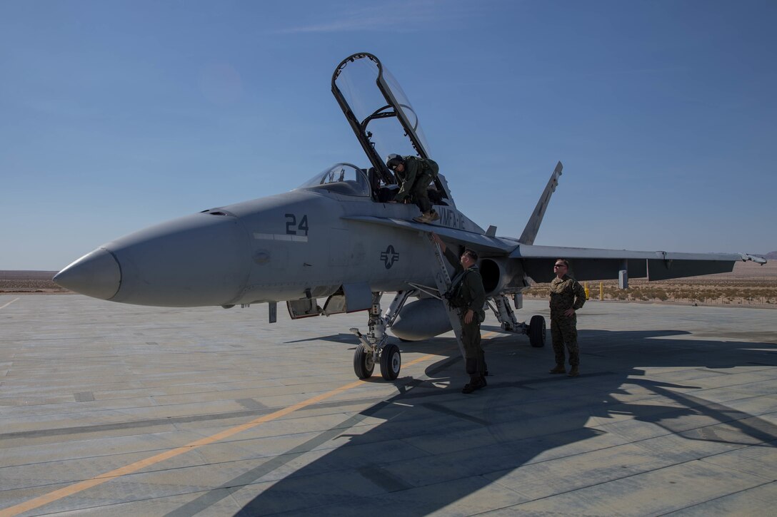 Lt. Col. Jeremy Yauck, F/A-18 Hornet pilot with Marine Fighter Attack Squadron 112, Marine Aircraft Group 41, 4th Marine Aircraft Wing, assists Col. Steven J. White, commanding officer of Marine Air Ground Task Force 23, exit the F/A-18 Hornet during Integrated Training Exercise 4-18 at Marine Corps Air Ground Combat Center Twentynine Palms, California, June 10, 2018. ITX 4-18 provides MAGTF elements an opportunity to undergo a service-level assessment of core competencies that are essential to expeditionary, forward-deployed operations. (U.S. Marine Corps photo by Lance Cpl. Samantha Schwoch/released)
