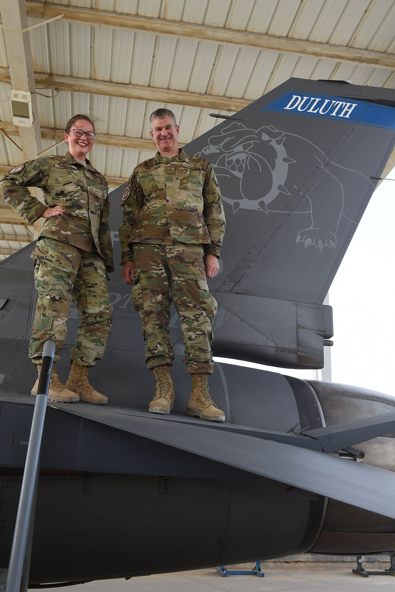 Father and daughter stand on wing on F-16 Fighting Falcon