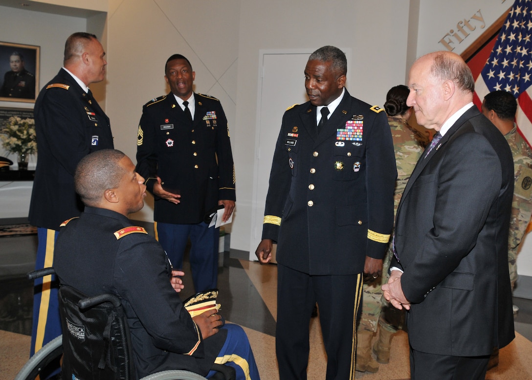 DLA Director Army Lt. Gen. Darrell Williams (second from right) and (far right) keynote speaker Army Lt. Gen. Mitchell Stevenson (retired) speak with Army Maj. Jeremy Haynes (seated), who was injured while deployed to Operation Freedom's Sentinel in Afghanistan. Photo by Teodora Mocanu.