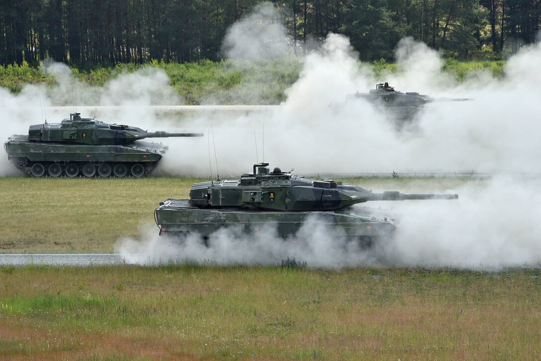 Swedish soldiers maneuver their Stridsvagn 122 main battle tanks.