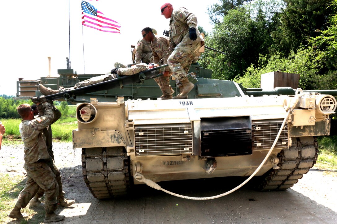 U.S. soldiers move a role-playing casualty off from a M1A1 Abrams tank.