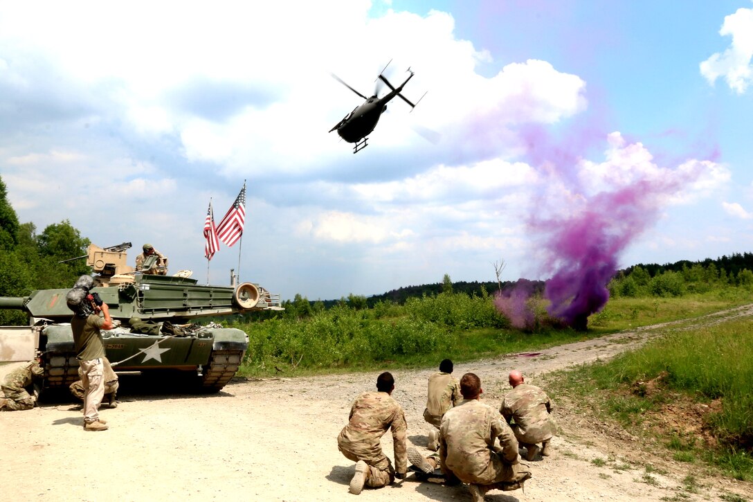 U.S. soldiers prepare to move a role-playing casualty onto an approaching helicopter.