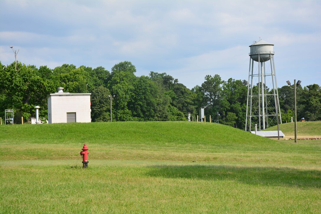 Photo depicts underground fuel tanks at Defense Fuel Support Point Yorktown, Virginia. A cement structure marks the area above the tanks.