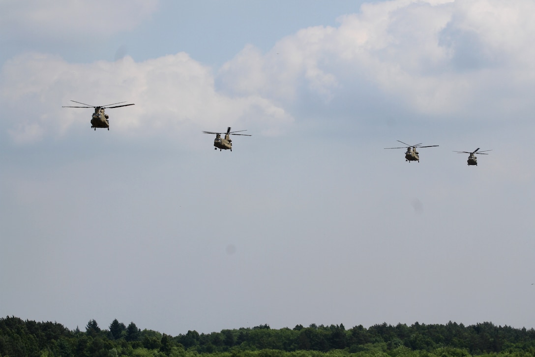 Four Army CH-47 Chinook helicopters prepare to land.