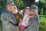 Master Sgt. Rodolfo Gamez and his wife, Tech. Sgt. Christina Gamez, hold their children, Tomas, 4, and Eva, 3, for a portrait outside of their home.
