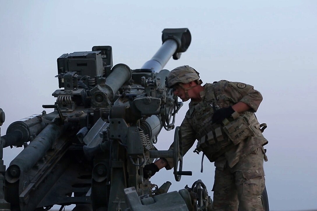 U.S. soldiers and Iraqi Security Force prepare to fire a howitzer.