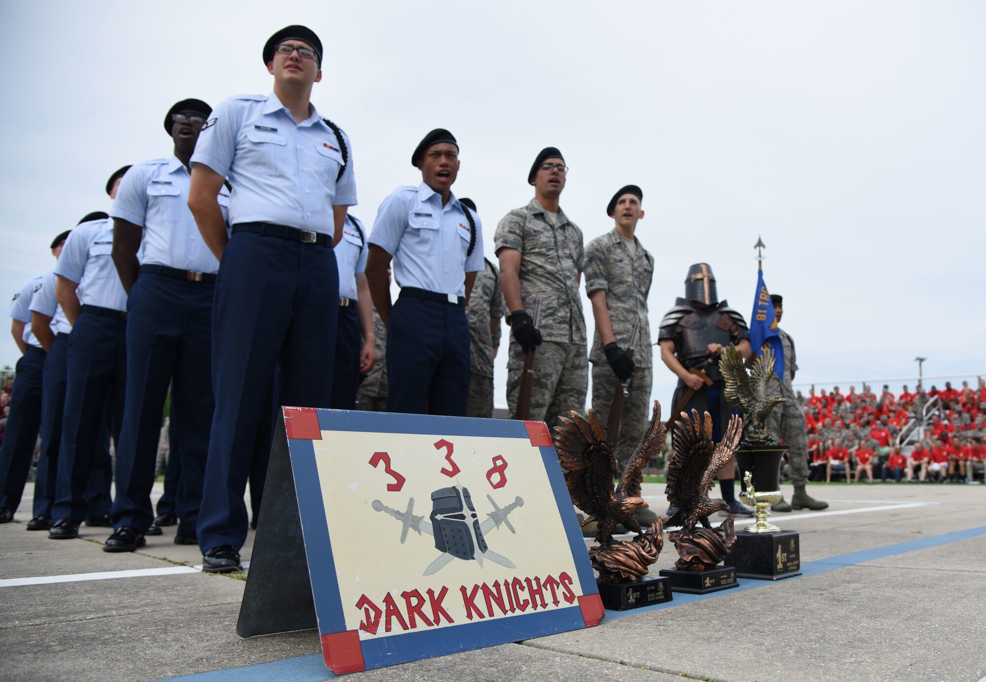 Members of the 338th Training Squadron drill team stand in formation behind their winning trophies during the 81st Training Group drill down on the Levitow Training Support Facility drill pad at Keesler Air Force Base, Mississippi, June 15, 2018. Airmen from the 81st TRG competed in a quarterly open ranks inspection, regulation drill routine and freestyle drill routine. The 338th TRS “Dark Knights” took first place overall this quarter. (U.S. Air Force photo by Kemberly Groue)
