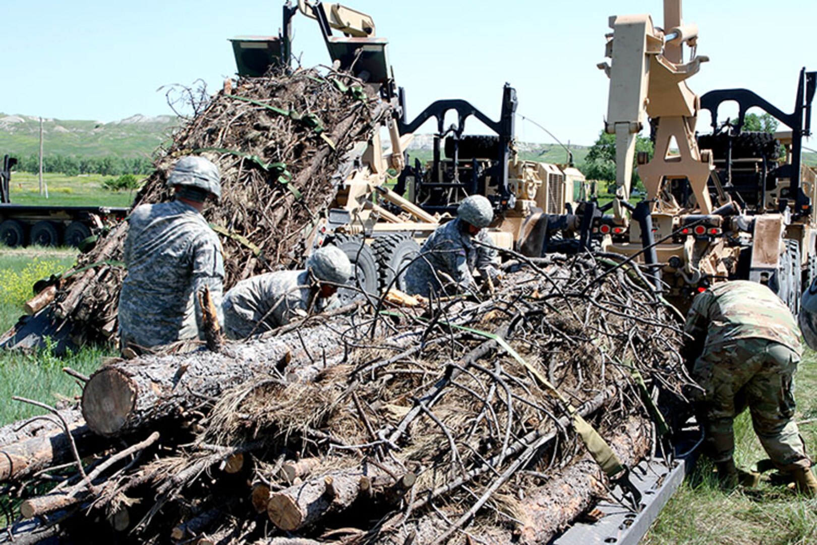 Soldiers from the 137th Transportation Company, Kansas Army National Guard, loosen straps on a load of timber at Red Shirt, S.D., June 15, 2018.