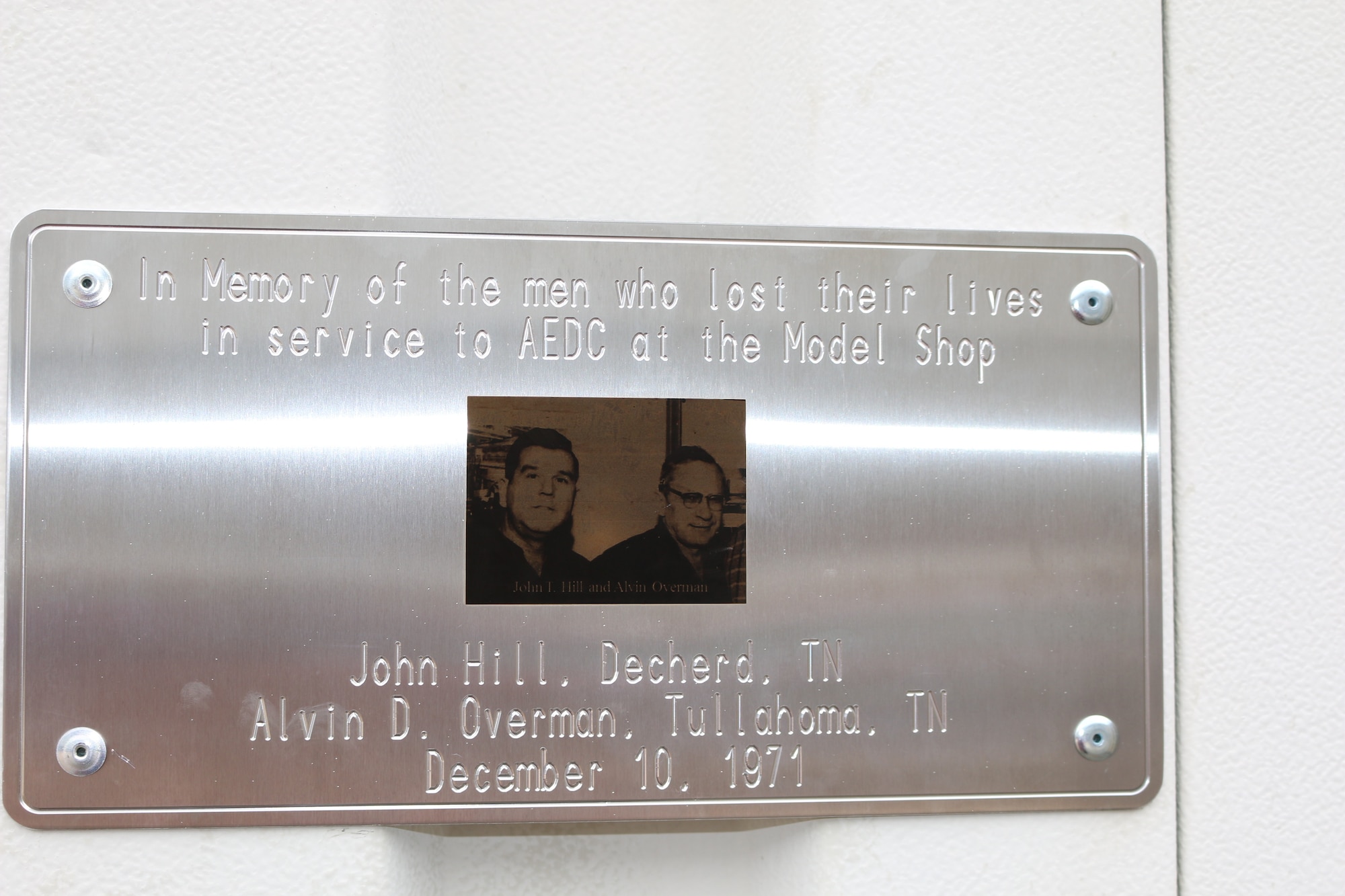 A plaque in memory of John Hill and Alvin Overman hangs on Building 446, the site of their Dec. 10, 1971, deaths. A memorial for the two Model Shop employees was held May 29. The event was also used to remind Manufacturing Group employees of the importance of safety and following procedures. (U.S. Air Force photo/Bradley Hicks)
