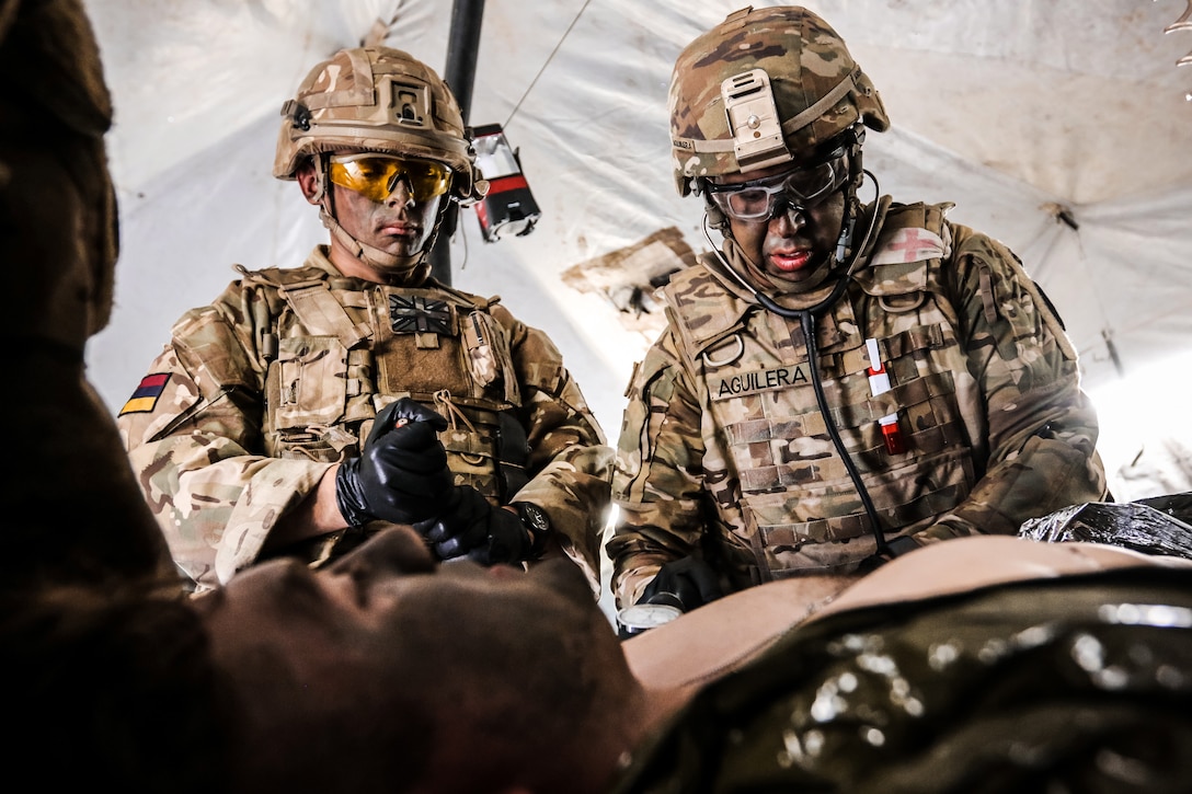 U.S. and U.K. soldiers perform first aid training on a soldier.