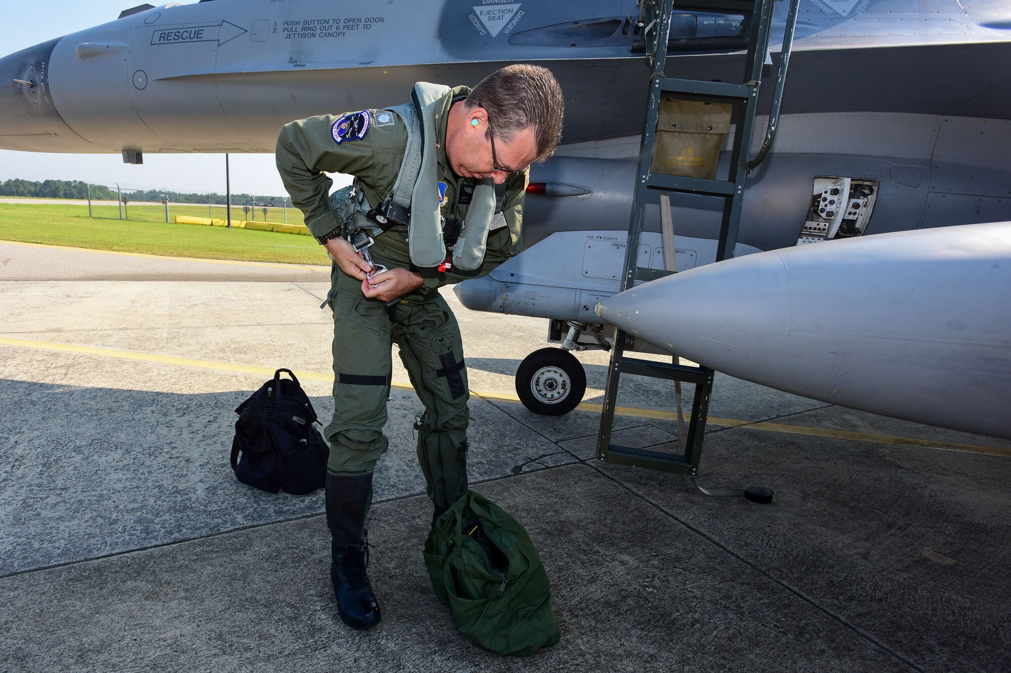 U.S. Civil Air Patrol Lt. Col. Brett Grooms, the legislative commander of the Civil Air Patrol's South Carolina Wing, secures his flight-suit gear prior to an aerospace control alert familiarization flight in an F-16 Fighting Falcon fighter jet from the 169th Fighter Wing here June 11. The 169th FW712, in close coordination with the Continental U.S. North American Aerospace Defense Command Region, the Eastern Air Defense Sector and the Federal Aviation Administration had recently hosted a Southeast Aerospace Control Alert June 5-7 but weather delays precluded Grooms from flying during the actual SACA event. The conference was a total team training initiative to improve homeland defense capabilities by developing techniques with joint forces during small-scale exercises. This conference consisted of South Carolina Air National Guard 169FW F-16 fighter jets, U.S. Coast Guard Rotary Wing Air Intercept Squadron MH-65D Dolphin helicopters from USCG Air Station Atlantic City and South Carolina Wing Civil Air Patrol aircraft and crews to hone their skills with tactical-level air-intercept procedures. (U.S. Air National Guard photo by Senior Airman Megan Floyd)