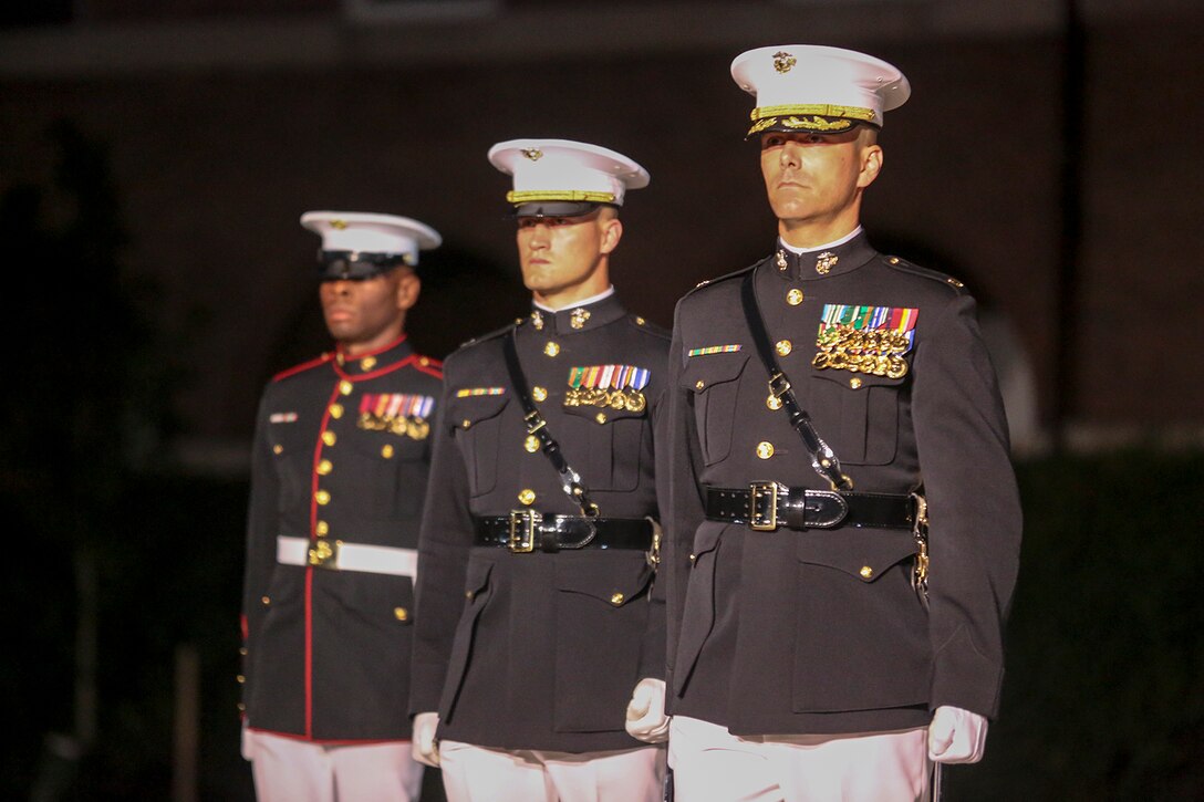 Marines with the Marine Barracks Washington D.C. parade marching staff stand at a ceremonial position on Center Walk during a Friday Evening Parade at the Barracks, June 15, 2018.