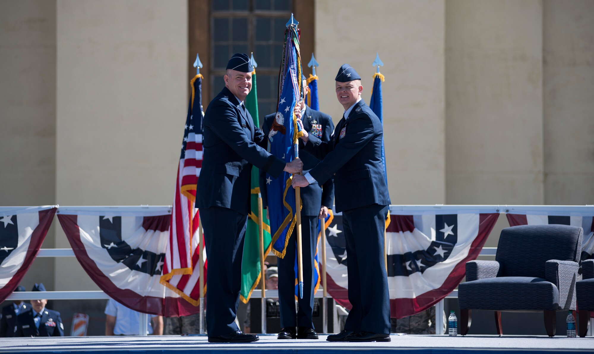 Brig. Gen. Darren James, 18th Air Force vice commander, passes the 92nd Air Refueling Wing guidon to Col. Derek Salmi, 92nd ARW commander, during an assumption of command ceremony June 15, 2018, at Fairchild Air Force Base, Wash. During the ceremony, a guidon is passed to symbolize the passing of responsibility of the wing to a commander. (U.S. Air Force photo/ Senior Airman Sean Campbell)