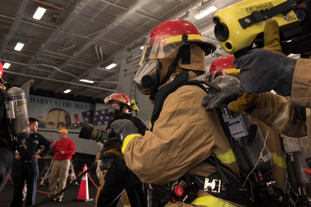 Navy Petty Officer 3rd Class Tilden Sansom uses a thermal imager during a firefighting drill in the hangar bay aboard the aircraft carrier USS Harry S. Truman in the Mediterranean Sea.