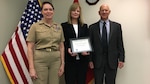 Commander of Defense Contract Management Agency International, Navy Capt. Sonya Ebright (left) and Robert Billington (right), DCMA Americas Director present Lori Hosie with her administrative contracting officer’s warrant in Ottawa, Ontario, Canada March 20. Hosie is currently the only DCMA local national employee who holds an active warrant. (DCMA photo by Kelli Zagata)