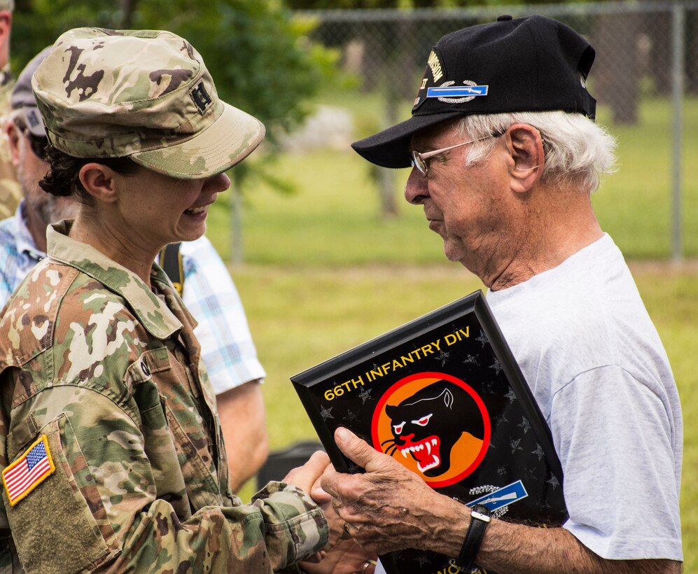 Army Capt. Kimberly Quinn enjoys a laugh with World War II Army veteran John Dietz following the 66th Infantry Division's final reunion and site dedication held at Camp Blanding Joint Training Center's Museum in Starke, Fla.