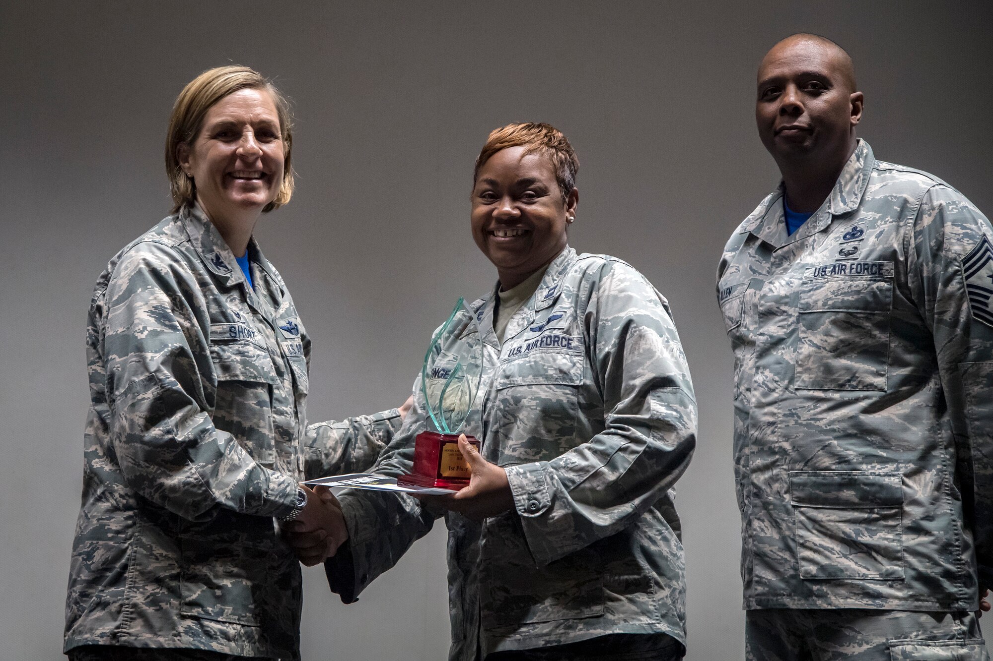 Col. Jennifer Short, left, 23d Wing (WG) commander, presents a 1st Place prize to Capt. Lakeatta Tonge, center, 23d Medical Group flight commander of education and training, following Spark Tank, June 15, 2018, at Moody Air Force Base, Ga. Spark Tank, a spinoff of the show Shark Tank, gave Airmen the opportunity to propose projects and improvements for Moody to leaders from the 23d WG and the local community. (U.S. Air Force photo by Airman 1st Class Eugene Oliver)