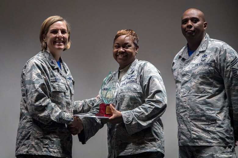 Col. Jennifer Short, left, 23d Wing (WG) commander, presents a 1st Place prize to Capt. Lakeatta Tonge, center, 23d Medical Group flight commander of education and training, following Spark Tank, June 15, 2018, at Moody Air Force Base, Ga. Spark Tank, a spinoff of the show Shark Tank, gave Airmen the opportunity to propose projects and improvements for Moody to leaders from the 23d WG and the local community. (U.S. Air Force photo by Airman 1st Class Eugene Oliver)