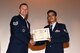 U.S. Air Force Tech. Sgt. Kyle Dobler, 312th Training Squadron fire inspector, hands Staff Sgt. Yamato Hart, 17th Civil Engineer Squadron Emergency Management journeyman, the Air Force Association Pitsenbarger Award during a Community College of the Air Force graduate ceremony at the base theater on Goodfellow Air Force Base, Texas, June 15, 2018. The award recognizes the students’ activities that indicate excellent leadership, citizenship, teamwork, community service, personal development and dedication. (U.S. Air Force photo by Staff Sgt. Joshua Edwards/Released)