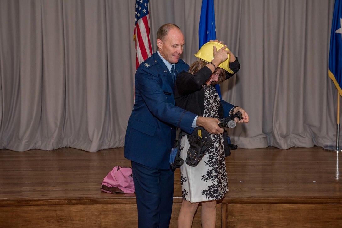 Col. Jason Schott gave his wife, Emily Schott, a hard hat and tool belt as a gift to help construct the house they plan to build in Colorado during his retirement. (Air Force Photo by Matt Williams)