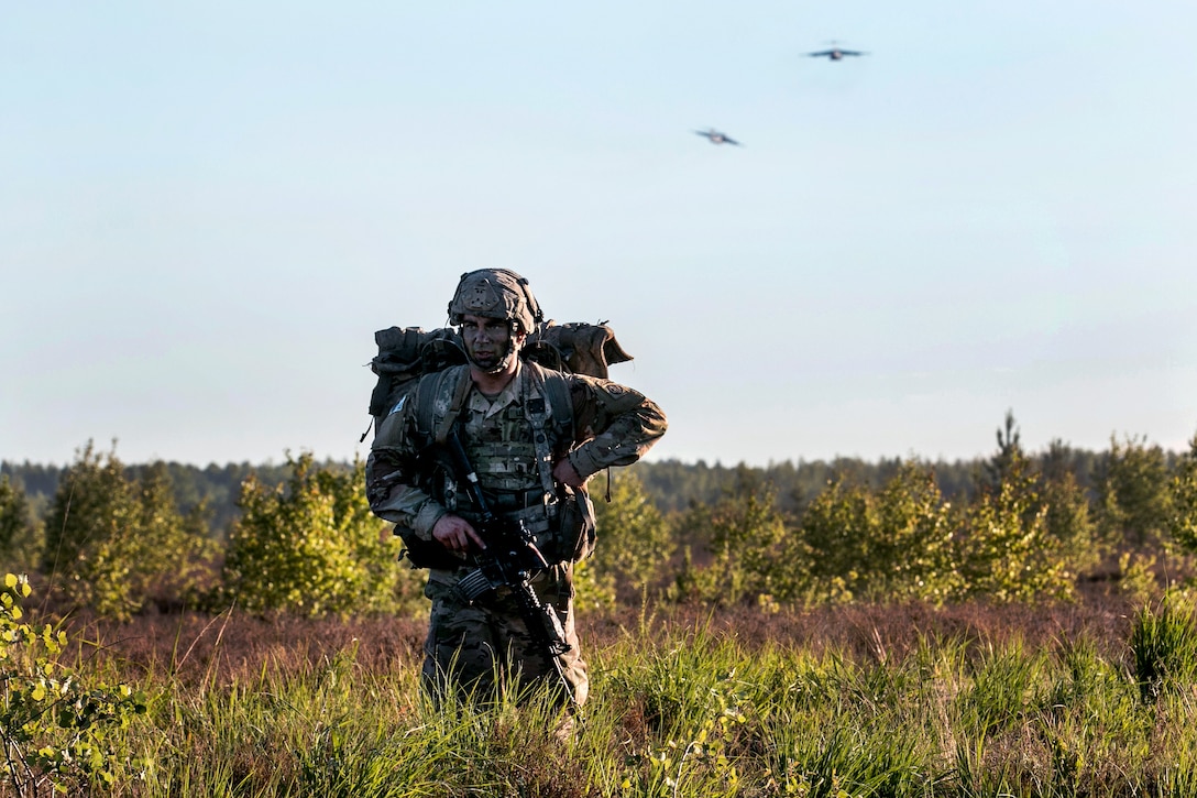 A soldier maneuvers to his assembly area after conducting airborne operation.