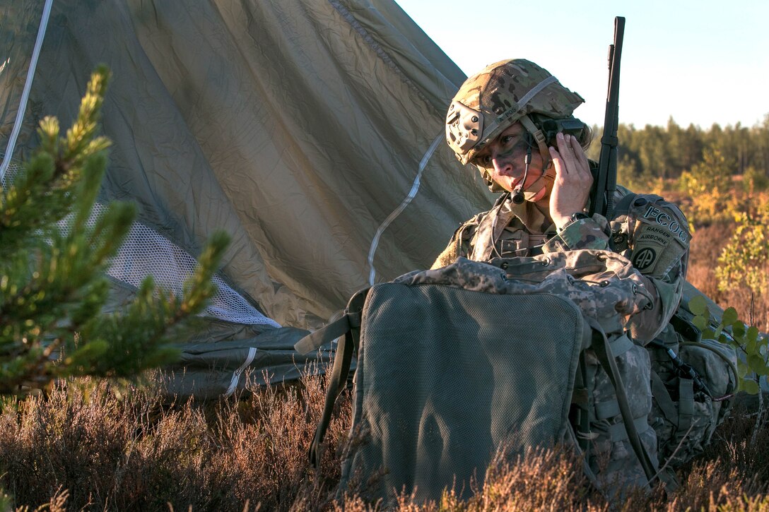 A soldier performs a radio check with his leadership team.