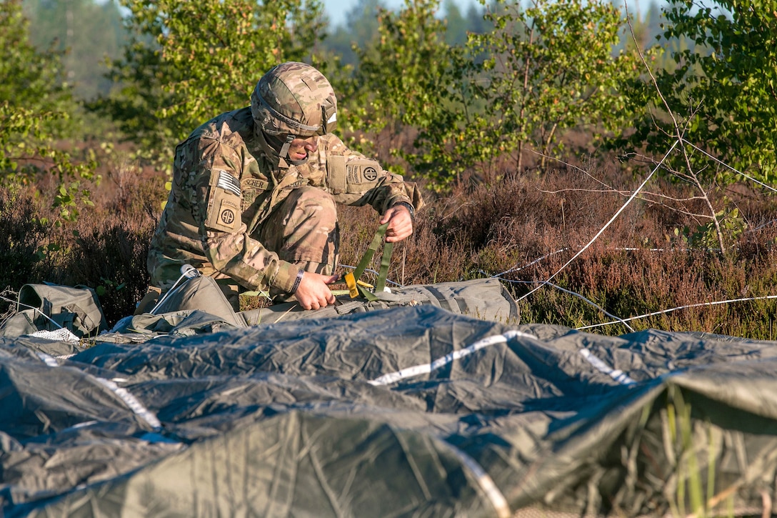 A soldier recovers his equipment after conducting airborne operation.