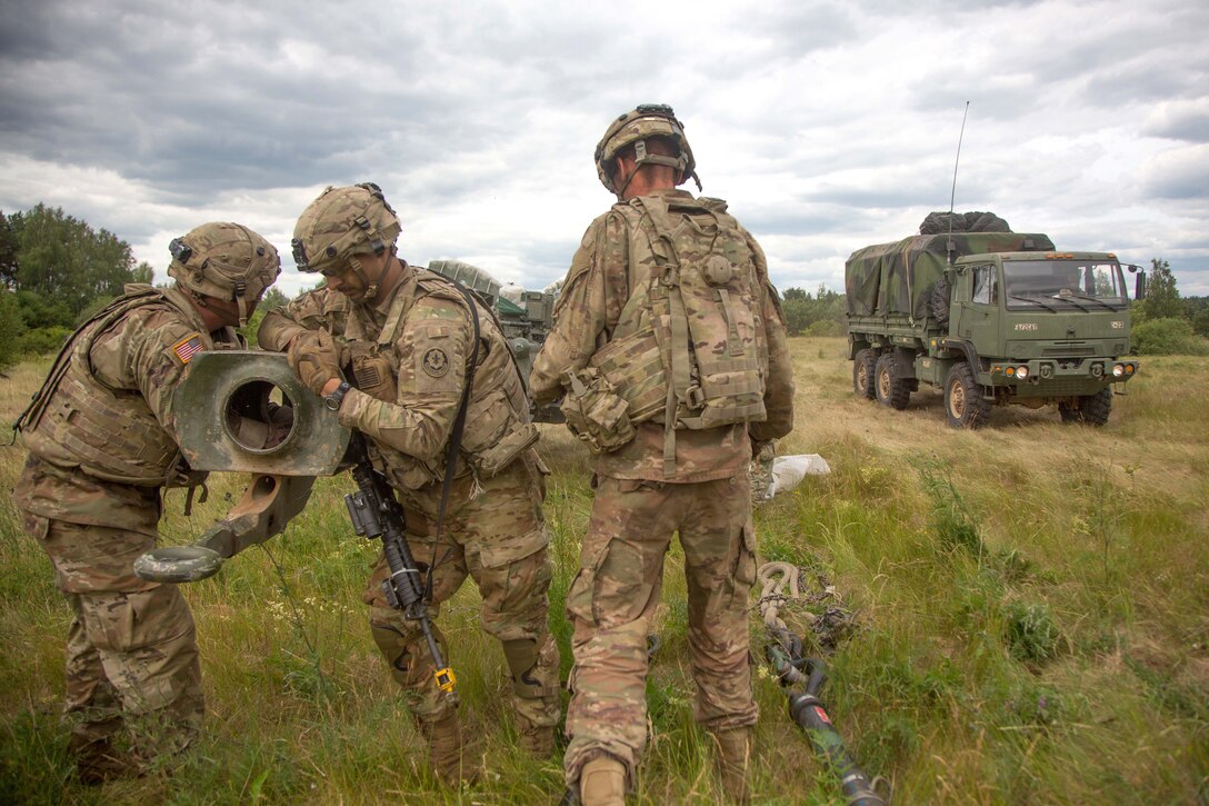 Soldiers align the barrel on an M777A2 155mm howitzer before being towed.