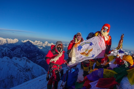 Matt Moniz, Mike Moniz, and guide pose for a photo on the summit of Mount Everest
with a U.S. 7th Fleet flag.  Photo courtesy of the Moniz family.