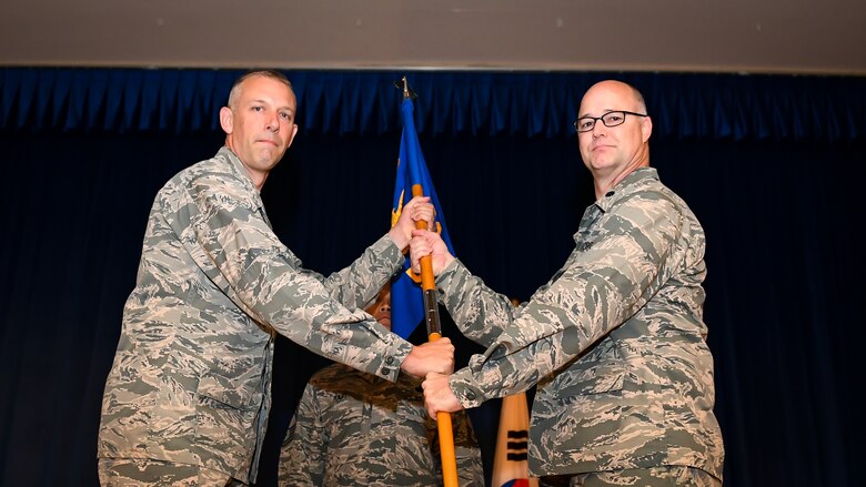 Col. Kevin Mantovani, 51st Mission Support Group commander, left, presents the guidon to Lt. Col. Austin Hood, 51st Communications Squadron commander, during a change of command ceremony at Osan Air Base, Republic of Korea, June 19, 2018.