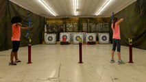 Two children bowl with bows and arrows during an archery training class put on by the Youth Center at Ellsworth Air Force Base, S.D., June 13, 2018. During this weeklong event, children learn the basics of archery and other games. (U.S. Air Force photo by Airman 1st Class Nicolas Z. Erwin)